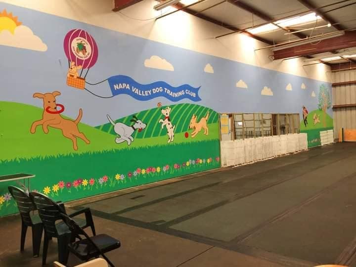 NVDTC training facility mural with playful cartoon dogs and hot air balloon